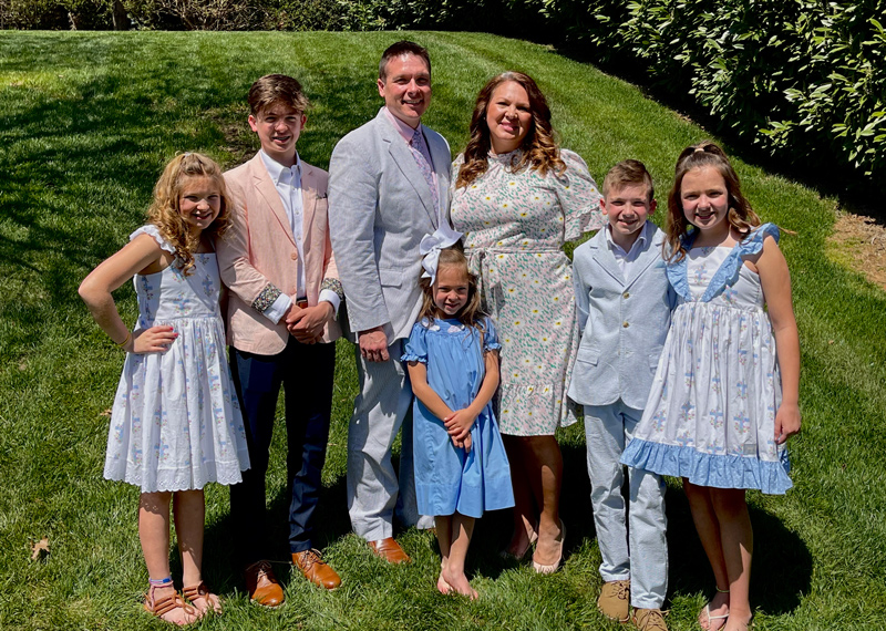 Doctor Dustin Clark with his wife Laura and their five children outdoors dressed sharply for Easter